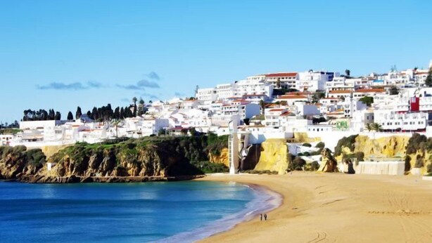 A coastal town with white buildings, a sandy beach, and a clear blue sea. - BnB Homes Apartment with cozy Terrace & Swimming pool near the heart city (Albufeira)
