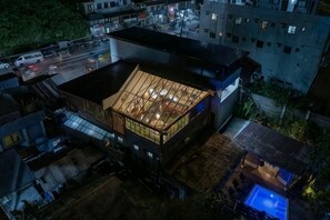 Ein modernes Gebäude mit großzügigem Innenraum, einer Dachterrasse und einem Schwimmbecken.