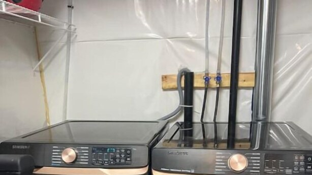 Two front-loading washing machines with control panels, placed side by side on a tiled floor. - Cutee Home in Prairie Pointe (Winnipeg)