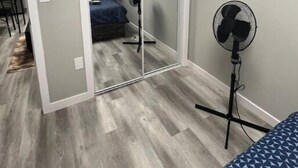 A bedroom with a sliding door closet, a standing fan, and a bed with a blue patterned bedspread. - Cutee Home in Prairie Pointe (Winnipeg)