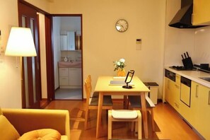 A compact living space with a dining area, a kitchen, and a visible bathroom. - Orange House Tsuruhashi|With Garage, Accommodates 8 People (Osaka)