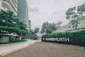 A building entrance with a sign reading 'AZURE NORTH' and a gravel pathway leading to the entrance.