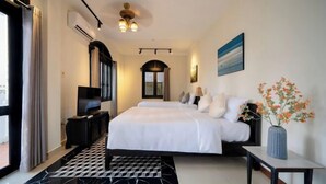 A modern hotel room with a large bed, a TV, and a view of the city. - Sila Vana Villa - Private 7BRs Pool Villa My Khe Beach Da Nang (Da Nang)