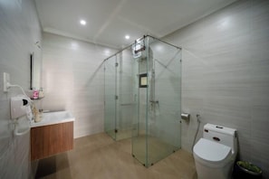 A modern bathroom with a glass-enclosed shower, a wooden vanity, and a white toilet. - Sila Vana Villa - Private 7BRs Pool Villa My Khe Beach Da Nang (Da Nang)