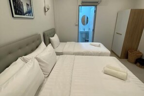 A hotel room with two beds, a wardrobe, a framed picture on the wall, and a bathroom visible through an open door. - TWOHOME Near Nimman (Chiang Mai)