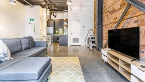 A modern interior with a sofa, TV, and kitchen area.