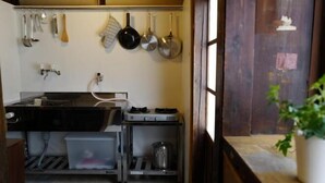 Una cocina compacta con un lavamanos, estufa y varios utensilios colgando.