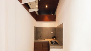 Una cocina compacta con un lavamanos integrado, una estufa y una pequeña encimera.