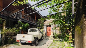 Una camioneta pickup blanca estacionada en una entrada de casa, con un camino de piedra que conduce a una vivienda con puerta roja.