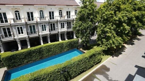 A multi-story building with a swimming pool, surrounded by well-maintained hedges and trees. - Sol Stay Sukhumvit 16 Entire House Three Bedroom & Full Kitchen (Bangkok)