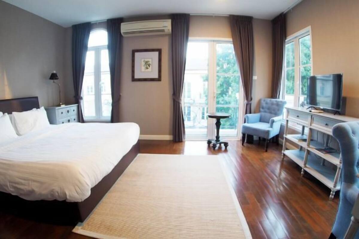 Une chambre d’hôtel avec un grand lit, une télévision, un bureau et une chaise.