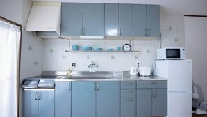 A kitchen with blue cabinets, a microwave, a sink, and a stove. - Vacation Stay Umekoji (Kyoto)