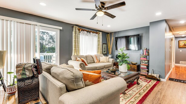 A living room with a sofa, a coffee table, and a ceiling fan.