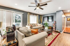 A living room with a sofa, a coffee table, and a ceiling fan.