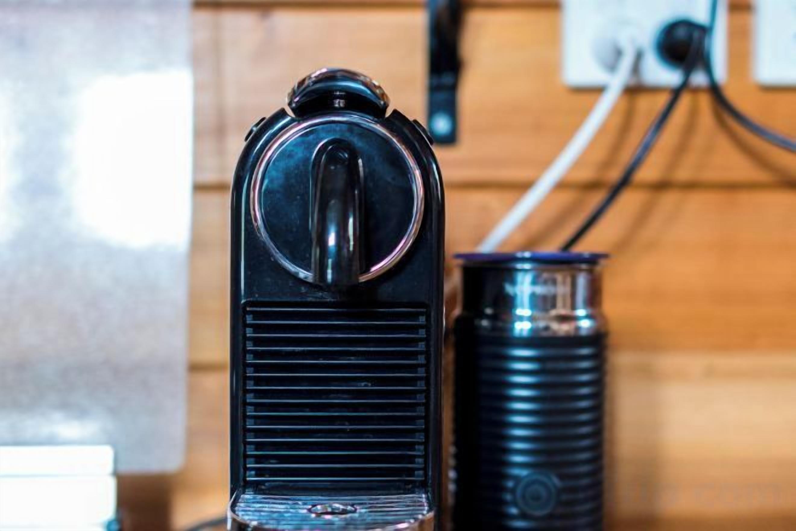 A vintage radio with a cylindrical speaker and a switch on top, placed on a wooden surface.