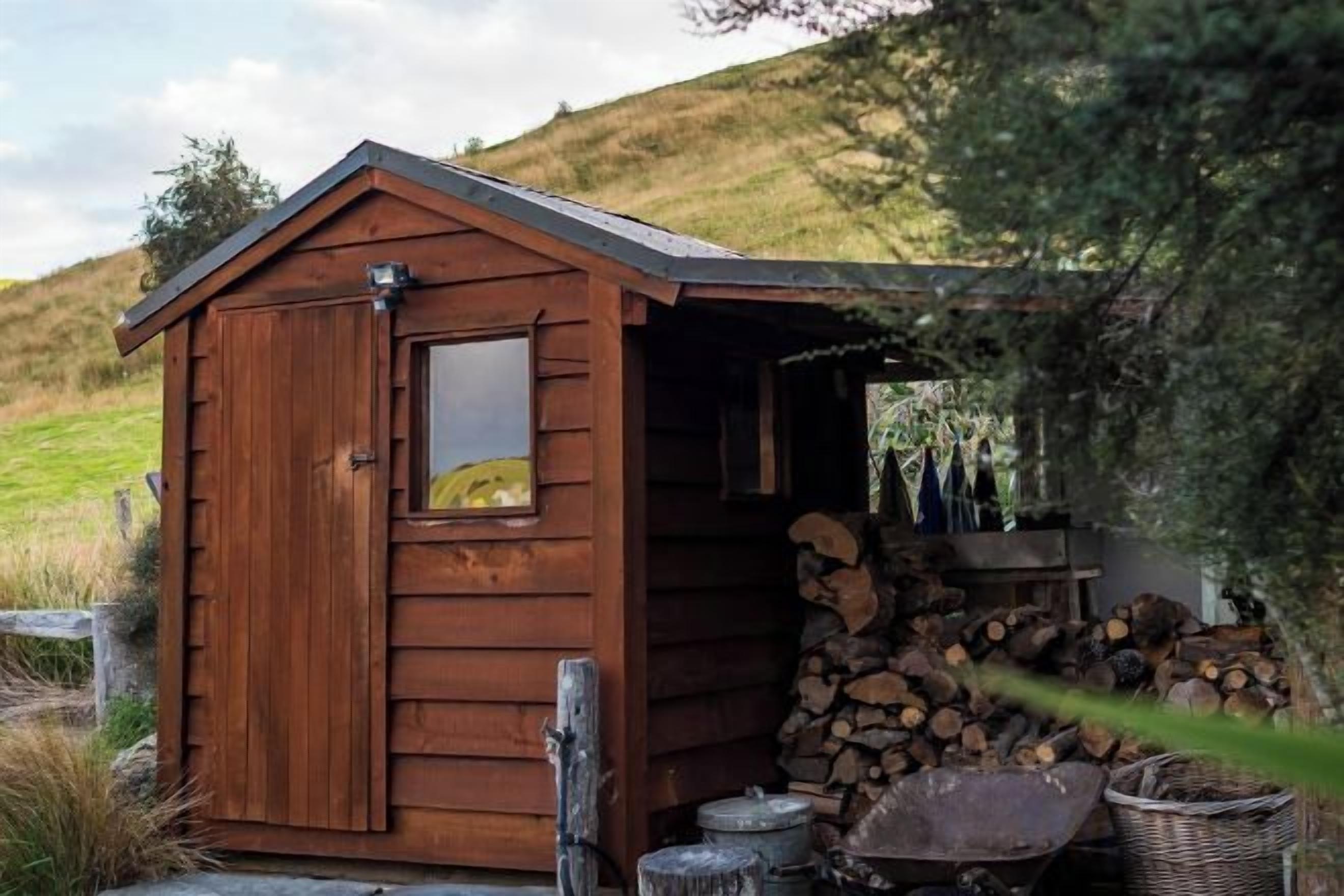 Une cabane en bois avec une porte, une fenêtre et un toit.