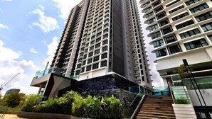 A high-rise building with multiple floors, a staircase leading to an upper level, and a landscaped area with plants.
