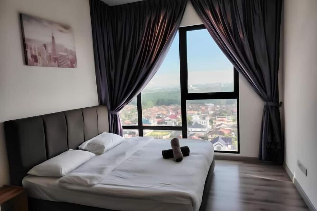 A bedroom with a large bed, a cityscape view through a window, and a city skyline painting on the wall.