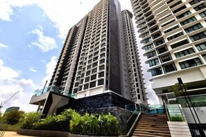 A high-rise building with multiple floors, a staircase leading to the entrance, and a glass facade. - Cityview MidValley Southkey 2BR+2FREE 16FL BY NATOL (Plentong)