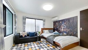 A bedroom with a bed, a sofa, a small table, and a large window. - japan house shinkoiwa (Tokyo)