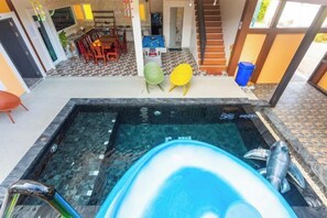 A swimming pool with a hot tub, a staircase, and a dining area with chairs and a table. - 99 Pool Villa (Pattaya)