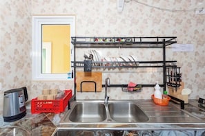 A kitchen with two stainless steel sinks, a dish rack, and a red crate. - 99 Pool Villa (Pattaya)