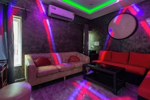 A room with a sofa, a red couch, and a coffee table. - 99 Pool Villa (Pattaya)