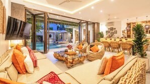 A modern living room with a sofa, coffee table, and wicker chairs. - Villa Chili in Dalung (Bali)