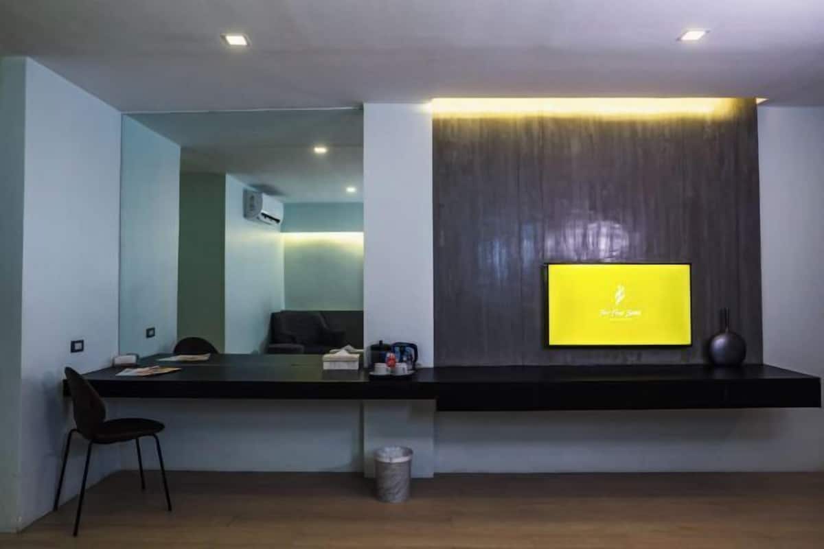 A modern reception desk with a flat-screen TV, a chair, and a trash bin.