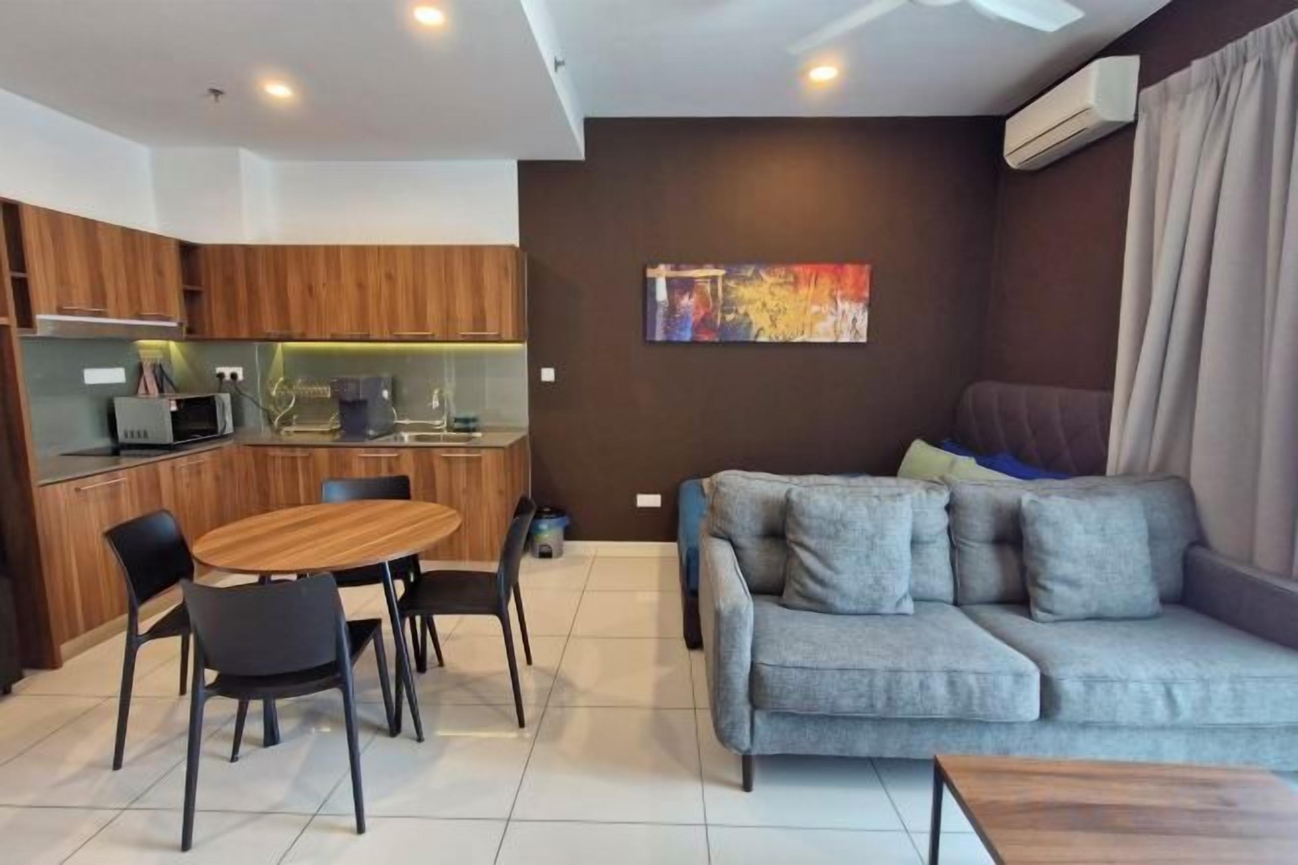 A modern living area with a sofa, dining table, and kitchen.