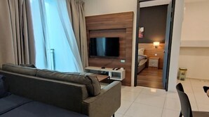 Una sala de estar moderna con un sofá, un televisor y una mesita.