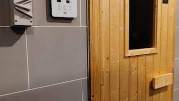 A wooden door with a window, a wall-mounted electrical box, and grey tiles.