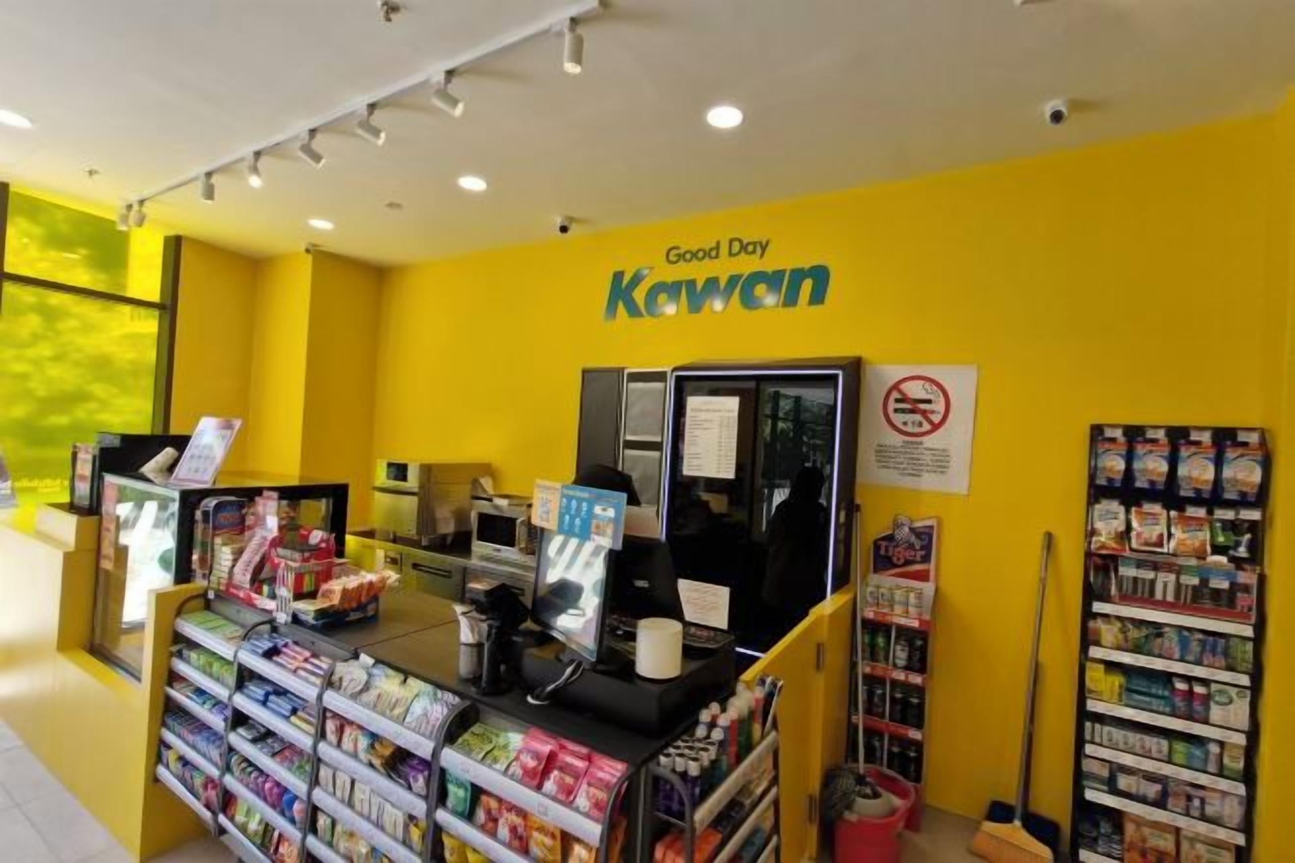 A Kewan store with a yellow interior, a checkout counter, and shelves stocked with products.