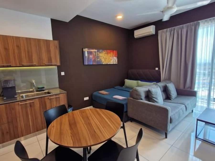 A compact living space with a kitchenette, a sofa, a dining table, and a view of the outdoors.