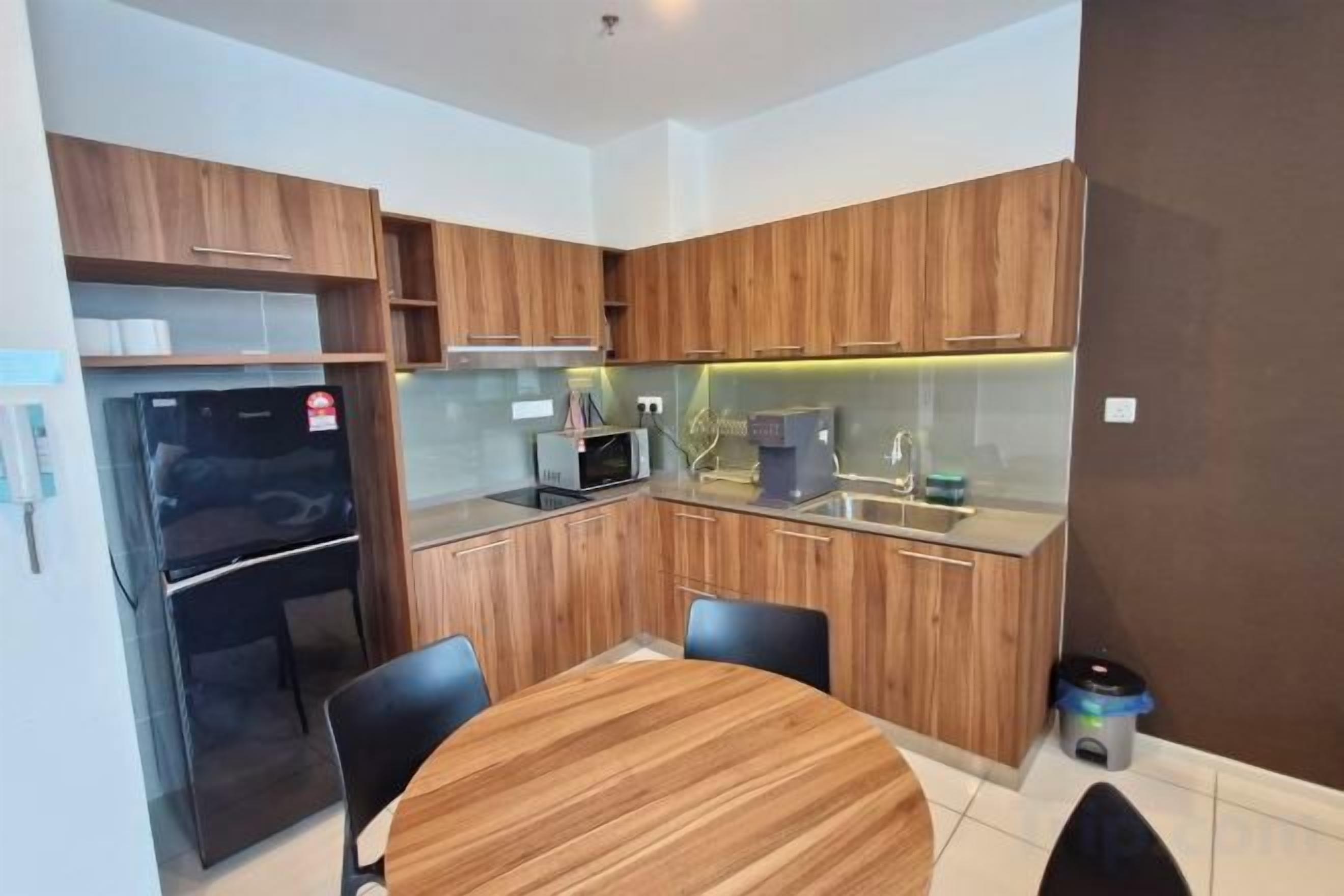 Una cucina moderna con mobili in legno, forno a microonde integrato e un tavolo da pranzo rotondo con sedie.