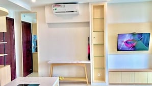 A modern living room with a TV mounted on the wall, a built-in bench, and a small table. - LukaHomes - Dcapitale/1BR+/City view (Hanoi)