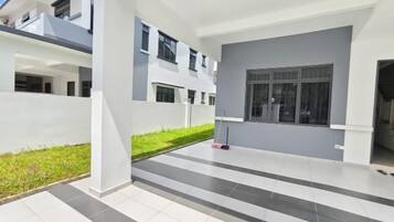 A modern building with a flat roof, large windows, and a tiled floor.
