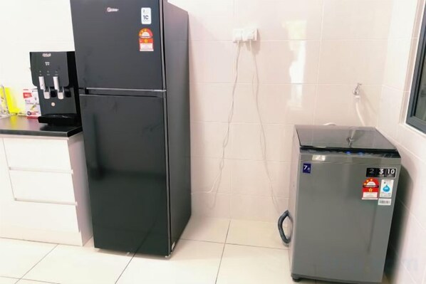 A kitchen with a black refrigerator, a small gray refrigerator, and a coffee machine. - 960 Taman Lagenda Kulai Johor Malysia (Kulai)