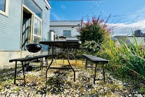 A backyard with a barbecue grill, picnic table, and outdoor seating area. - 2-floor house with garden (Otaru)