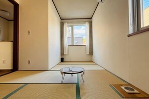 A room with tatami flooring, a tatami mat table, a window with curtains, and a view of the sky. - 2-floor house with garden (Otaru)