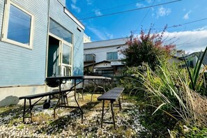 A residential area with a blue house, a picnic table, and a small garden. - 2-floor house with garden (Otaru)