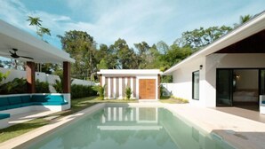 A modern house with a swimming pool, a covered patio, and a large window overlooking the pool. - Samui Paradise Poolside Villa (Koh Samui)