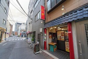 A narrow street with a restaurant on the right, a bicycle parked outside, and a red sign above the entrance. - House TOKYO ASAKUSA (Tokyo)