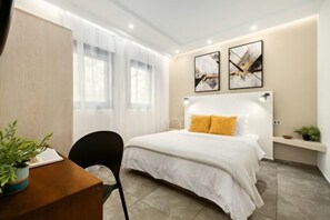 Un dormitorio moderno con una cama, un escritorio y dos cuadros en la pared.