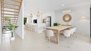 A modern kitchen with white cabinetry, a central island, and pendant lighting. - Seabreeze (kingscliff)