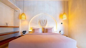 A modern bedroom with a large bed, two pendant lights, and a unique wall hanging. - Villa Terracotta by Pertama Stay (Bali)
