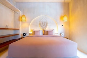 A modern bedroom with a large bed, two pendant lights, and a unique wall hanging. - Villa Terracotta by Pertama Stay (Bali)