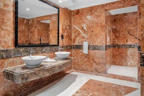 A bathroom with two sinks, a large mirror, and a shower area. - Pickalbatros Luxury Suites (Sharm El Sheikh)