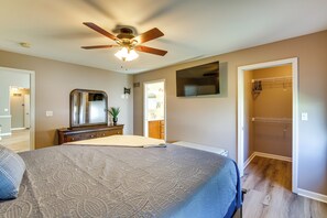 A bedroom with a bed, a ceiling fan, a dresser, a mirror, and a walk-in closet. - Bar, Pool Table & Yard! Spacious Union Home (Union)