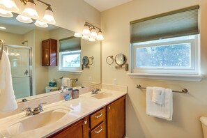 A bathroom with two sinks, a large mirror, and a window with blinds. - Bar, Pool Table & Yard! Spacious Union Home (Union)
